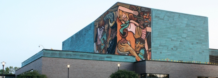 Contemporary building with a large colorful mural covering the upper exterior wall.