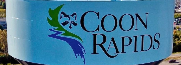 Coon Rapids water tower featuring the city logo with stylized raccoon mask and flowing river design.