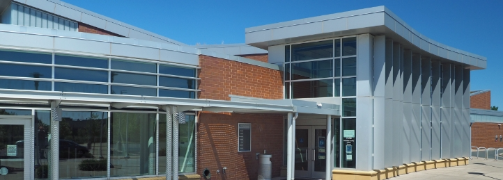 Modern community or civic center with curved rooflines, glass walls, and brick exterior architecture.