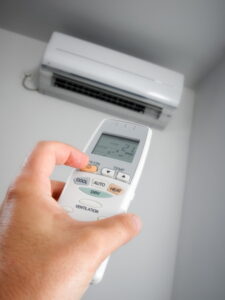 hand-turning-on-remote-for-ductless-air-handler